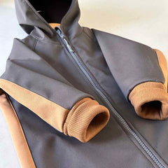 Detaliu al salopetei overall din material  impermeabil, softshell gri cu accent caramel. Odiseea lui Artur